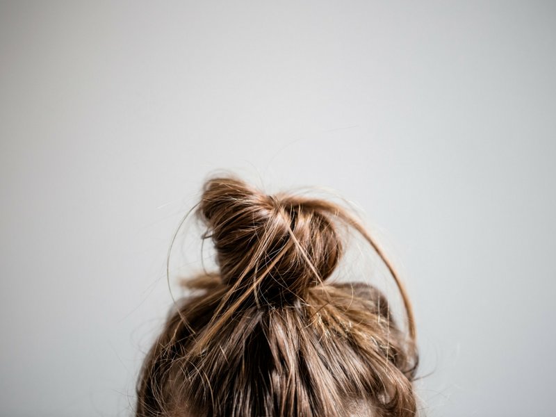 shot of a womans' top knot in need of bookedin