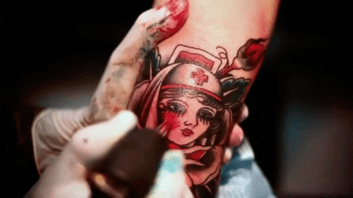 tattoo artist tattooing an arm