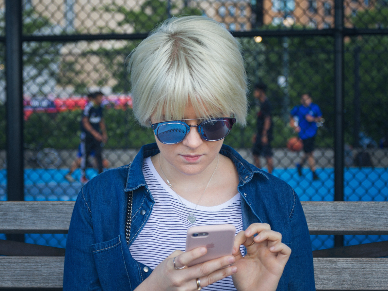 young blond woman is holding her phone