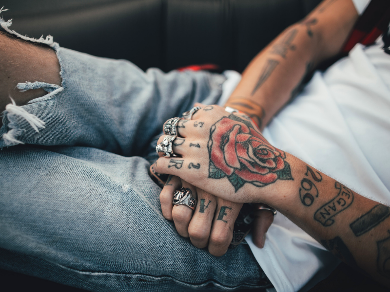 close up of tatttoed hands of man in car