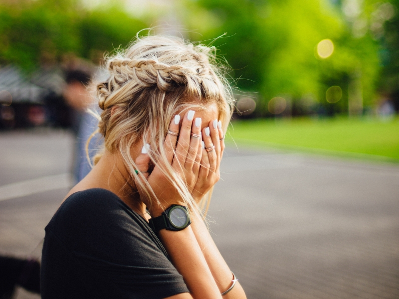 blond woman covers her face after making a mistake