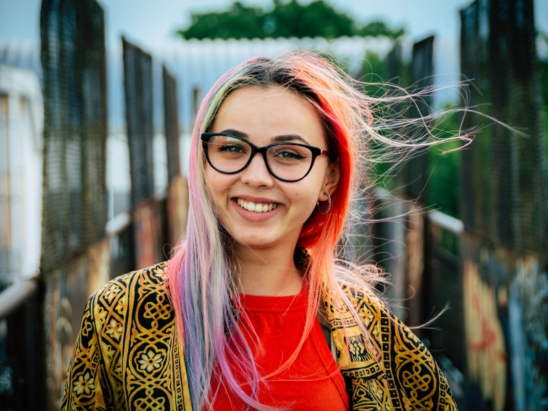 a woman with bright hair smiles into the camera