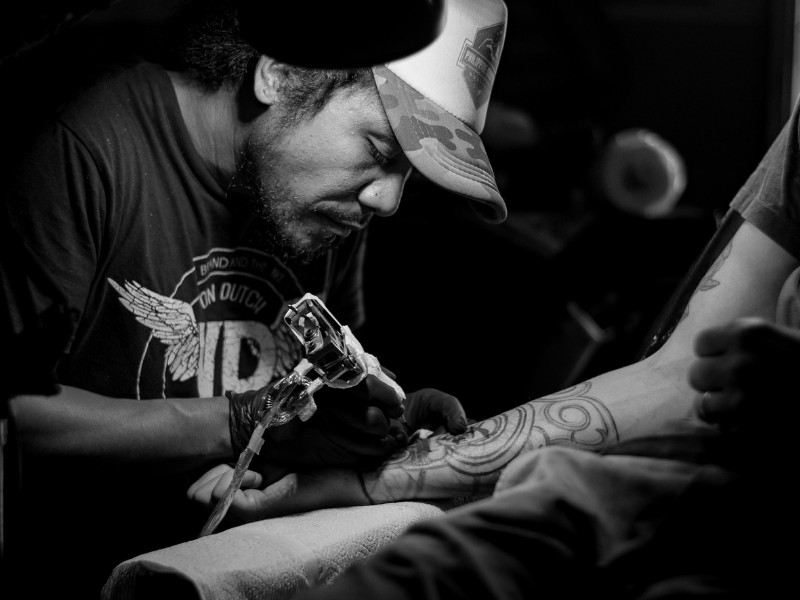 man in a tattoo shop doing a tattoo