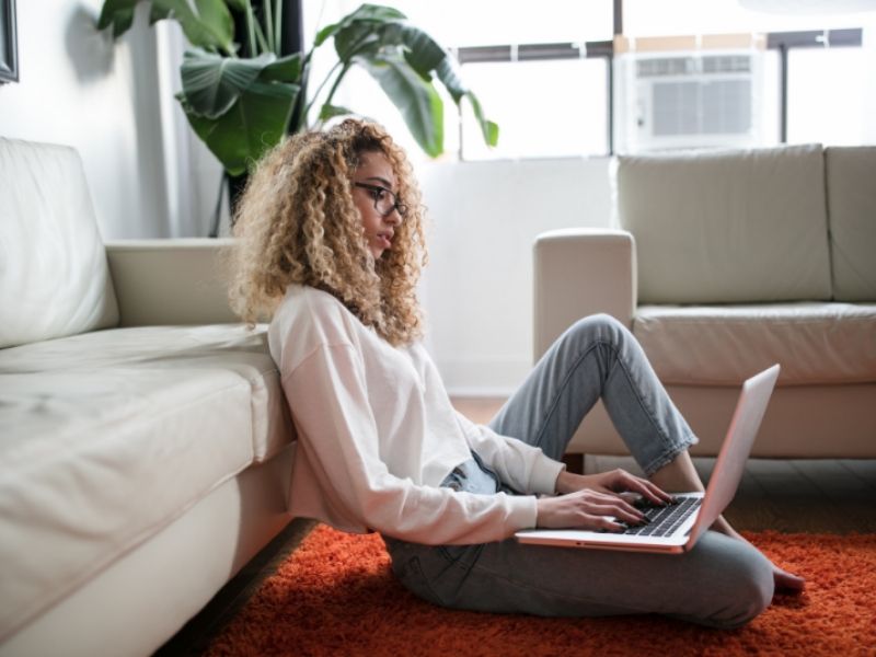 young lady looks at an online appointment booking app on her laptop