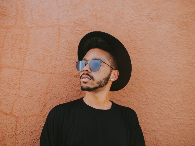 young man standing in front of an orange wall