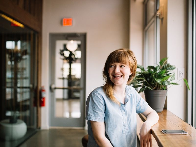 a happy young woman ready to set boundaries in a coffee shop