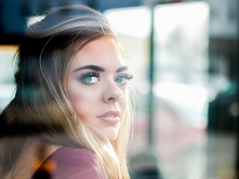 a young woman with large blue eyes looks out with empathy