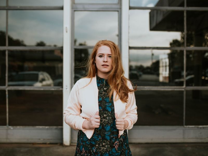 red headed woman in front of a building post COVID-19