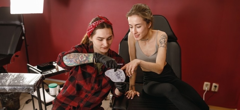 tattoo artist talking to client